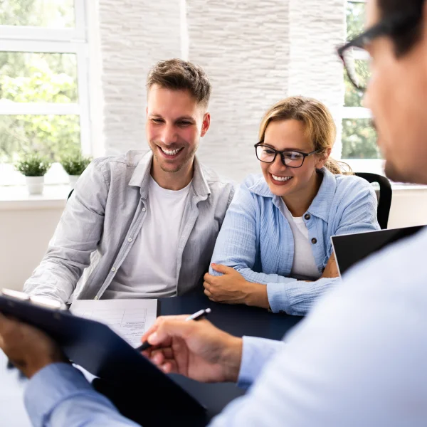 A man and woman review documents at a table, discussing a guaranteed acceptance personal loan.