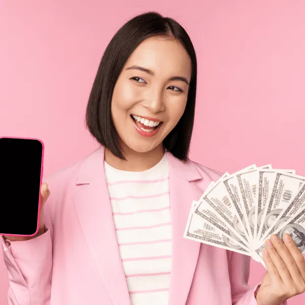 A woman in a pink suit holding a phone and money