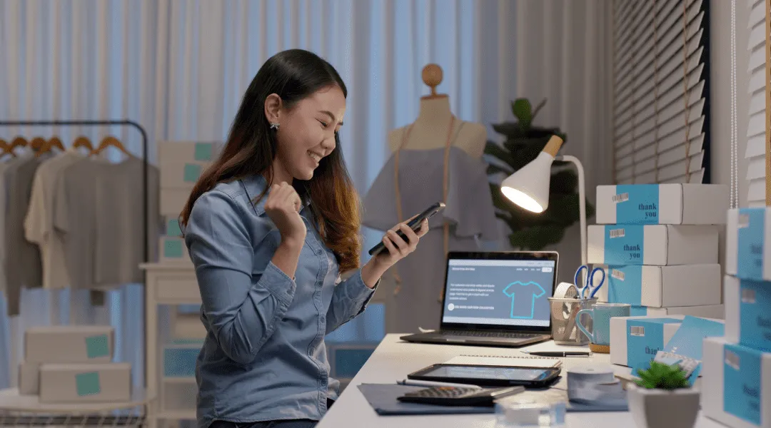 A woman sitting at a desk, focused on her phone